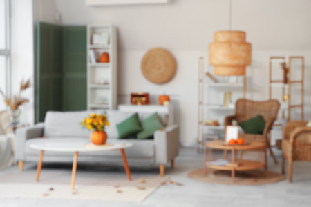 Blurred view of living room with pumpkins, sofa and armchairsの写真素材