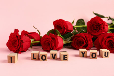 Red roses with text I LOVE YOU on pink background. Valentine's day conceptの写真素材