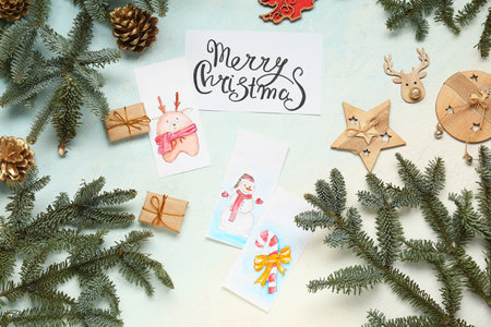 Composition with beautiful Christmas cards, decorations and fir branches on light backgroundの写真素材