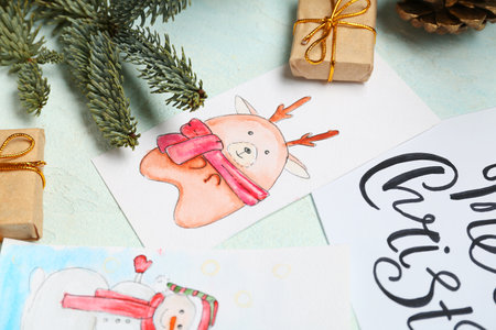 Beautiful Christmas cards, gifts and fir branches on light background, closeupの写真素材