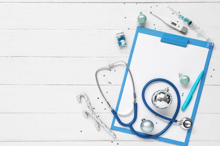 Composition with clipboard, medical supplies and Christmas decorations on light wooden backgroundの写真素材