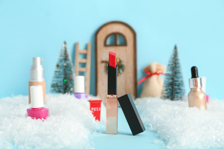 Beautiful Christmas composition with lipstick and decorative snow on blue backgroundの写真素材