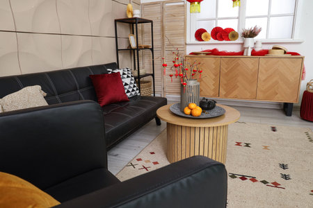 Interior of living room with black sofa, armchair and traditional Chinese decorations. Chinese New Year celebrationの写真素材