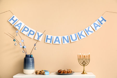 HAPPY HANUKKAH bunting and mantelpiece with traditional decorations near beige wallの写真素材