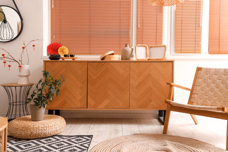 Interior of festive living room with armchair, wooden cabinet and traditional Chinese decorations....