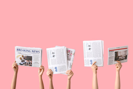 Female hands with different newspapers on pink backgroundの写真素材