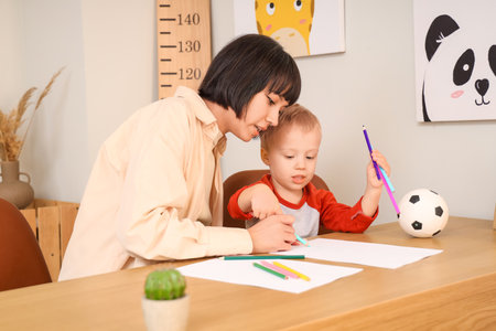 Happy mother with her little son drawing at homeの写真素材