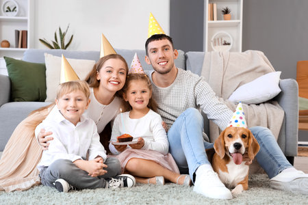 Happy family with Beagle dog celebrating Birthday at homeの写真素材