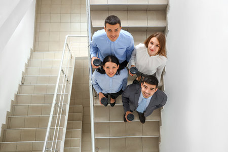 Business colleagues having coffee break on stairs in office, top viewの写真素材