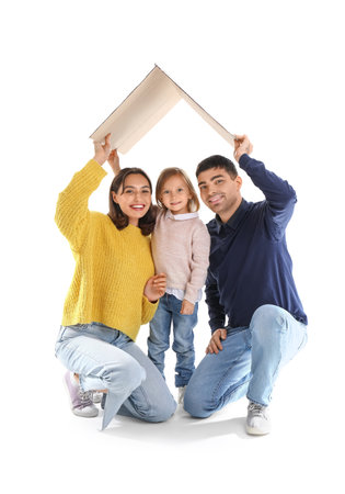 Happy family with cardboard in shape of roof dreaming about their new house on white backgroundの写真素材
