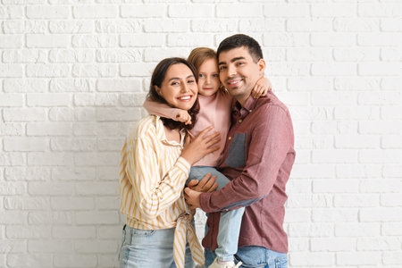 Happy family dreaming about their new house on white brick backgroundの写真素材
