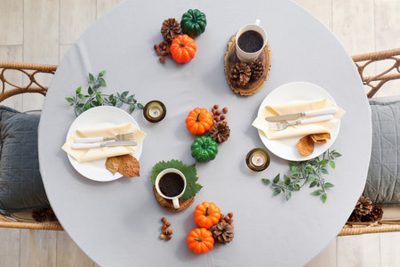 Autumn table setting with pumpkins, burning candles and leavesの写真素材