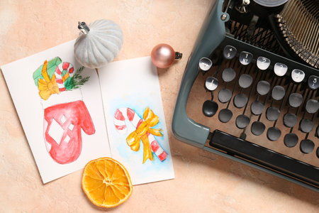 Vintage typewriter with Christmas decor and postcards on beige grunge backgroundの写真素材