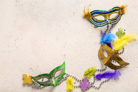 Carnival masks with feathers and beads for Mardi Gras celebration on light grunge backgroundの写真素材