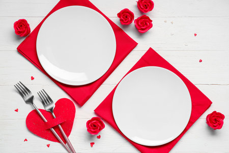 Beautiful table setting for Valentine's Day with decorative roses and hearts on white wooden backgroundの写真素材