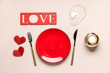 Beautiful table setting for Valentine's Day with the word LOVE, candle and hearts on beige backgroundの写真素材