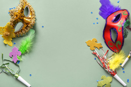 Carnival masks with party horns and decor for Mardi Gras celebration on green backgroundの写真素材