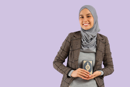 Young Muslim woman with Koran on lilac background. Ramadan celebration