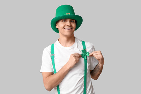 Happy tattooed young man in leprechaun's hat and with shamrock on light background. St. Patrick's Dayの写真素材