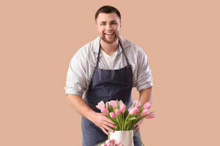 Male florist with tulips on brown background. International Women's Day celebrationの写真素材