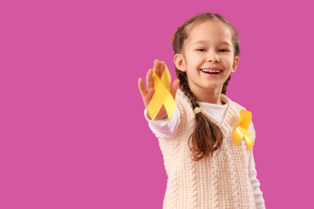 Cute little girl with yellow ribbons on purple background. Childhood cancer awareness conceptの写真素材