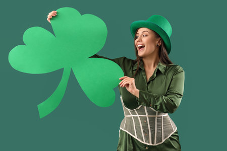 Young woman with paper clover on green background. St. Patrick's Day celebrationの写真素材