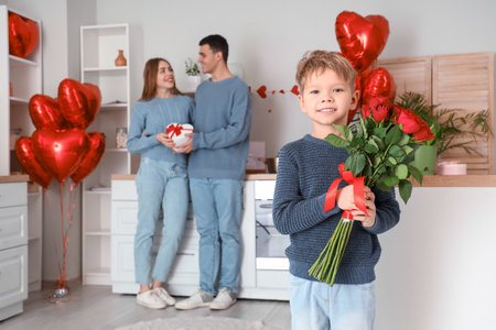Little boy with roses and his parents in kitchen on Valentine's Dayの写真素材
