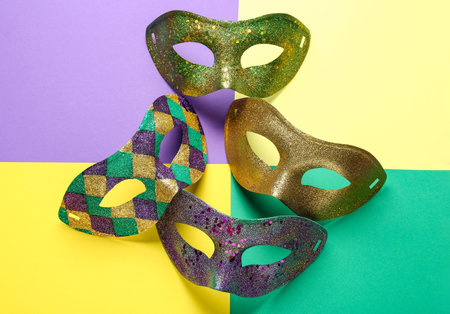 Shiny carnival masks for Mardi Gras celebration on color backgroundの写真素材