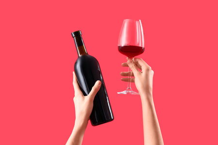 Woman with bottle and glass of wine on red background. Valentine's Day celebrationの写真素材
