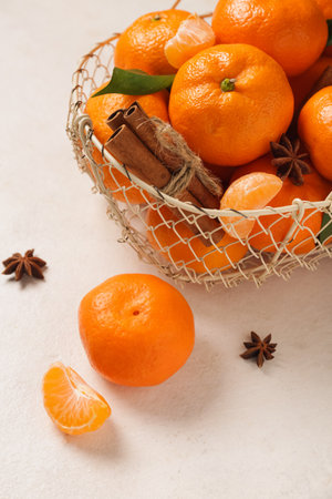 Basket of sweet mandarins with cinnamon and star anise on white backgroundの写真素材