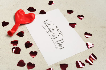 Card with text HAPPY VALENTINE'S DAY, empty balloon and hearts on light grunge background