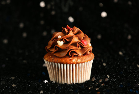 Tasty chocolate cupcake for Valentine's Day on dark blurred backgroundの写真素材
