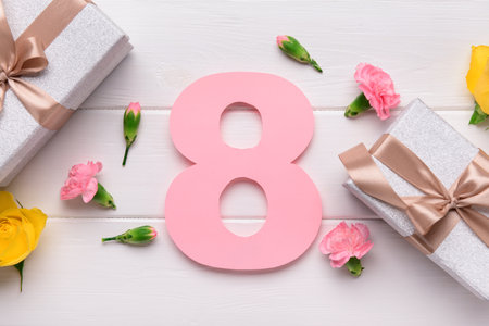 Figure 8 with gift boxes and beautiful flowers on white wooden background. International Women's Dayの写真素材