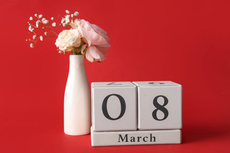 Cube calendar with date 8 MARCH and different beautiful flowers on red background. International...