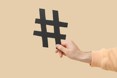 Man with hashtag sign on beige backgroundの写真素材