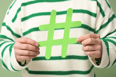 Man with hashtag sign on green background, closeup