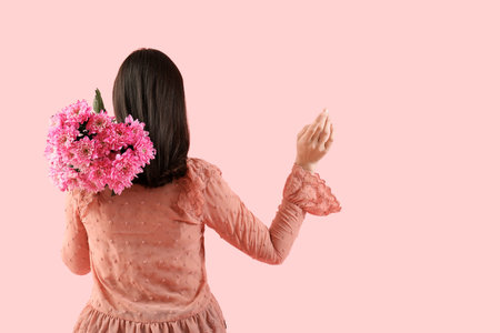 young woman with bouquet of pink chrysanthemum flowers on color background. International Women's Dayの写真素材