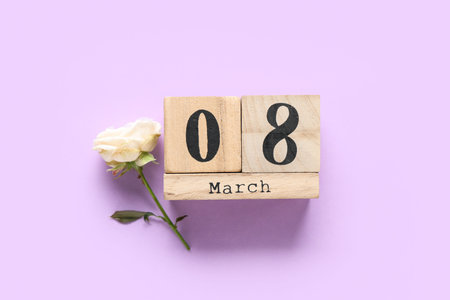 Cube calendar with date 8 MARCH and beautiful rose on lilac background. International Women's Day