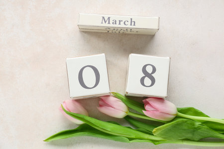 Cube calendar with date 8 MARCH and beautiful tulips on white background. International Women's Day