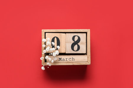 Cube calendar with date 8 MARCH and beautiful gypsophila flowers on red background. International Women's Dayの写真素材