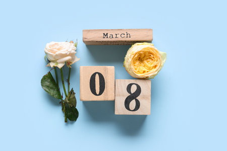 Cube calendar with date 8 MARCH and beautiful roses on blue background. International Women's Dayの写真素材