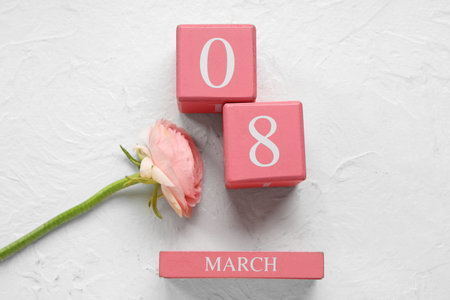 Pink cube calendar with date 8 MARCH and beautiful flower on white background. International Women's Dayの写真素材