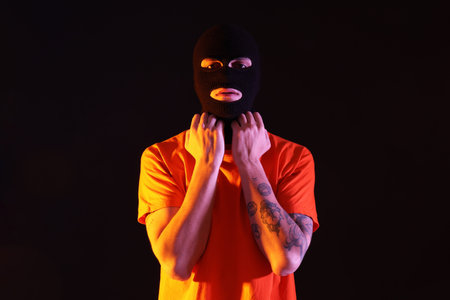 Handsome young man in balaclava on black backgroundの写真素材