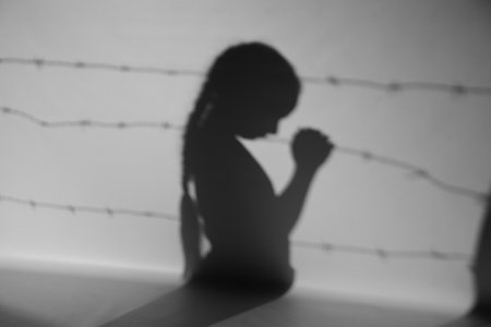 Shadow of little Jewish girl and barbed wire on gray background. International Holocaust Remembrance Dayの写真素材