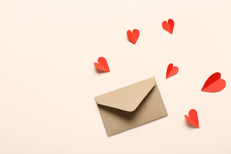 Composition with envelope and red paper hearts on light background. Valentine's Day celebrationの写真素材