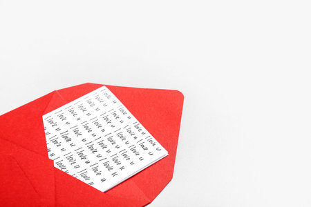 Card with text I LOVE U in red envelope against light background. Valentine's Day celebration