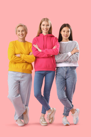 Portrait of beautiful women with crossed arms on pink backgroundの写真素材