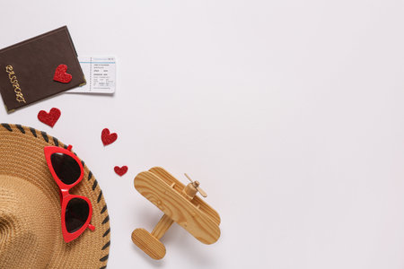 Travel accessories with hearts and wooden airplane on white background. Valentine's Day celebrationの写真素材