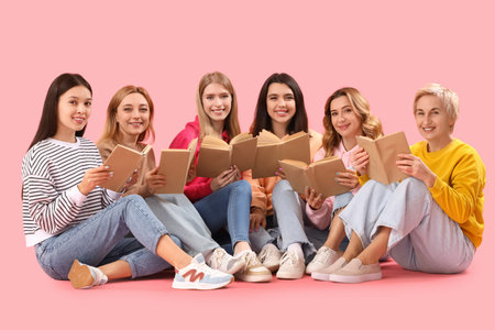 Portrait of beautiful women with books on pink background