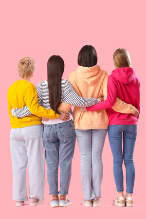 Hugging women on pink background, back viewの写真素材